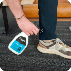 Personne utilisant un spray anti-moustique Kenavo sur son pantalon pour se protéger des piqûres. Exemple d'application d'un répulsif anti-moustique sur les vêtements.
