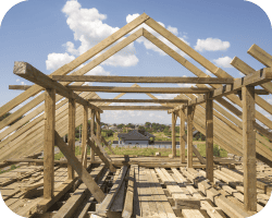 Charpente en bois d'une maison en construction montrant l'ossature et les poutres.