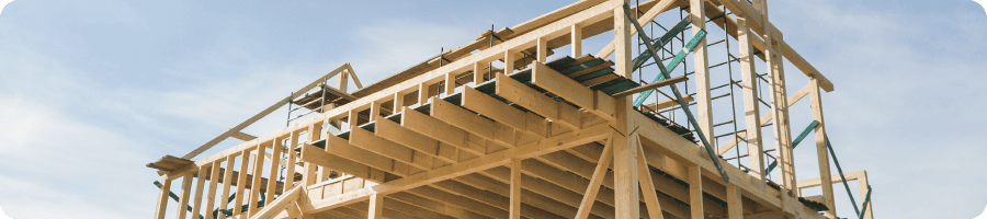 Charpente en bois d'une maison en construction montrant l'ossature et les poutres.
