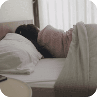  Une personne dort dans son lit, un sommeil de mauvaise qualité peut être un signe de la présence d'acariens.